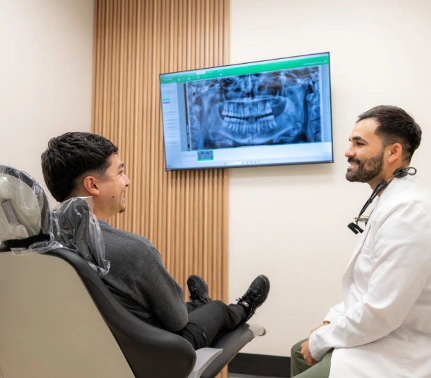 Dentist reviewing treatment information with a patient on a screen