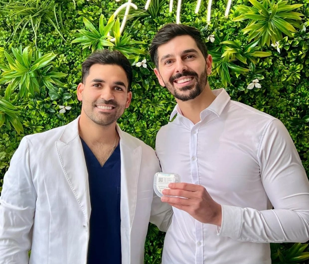 Two male dental professionals smiling together in the office