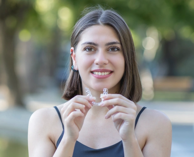 Patient reviewing Invisalign clear aligner tray during a consultation